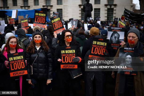 Demonstrators hold posters reading "UN Women, your silence is loud" along pictures of Israeli women being held hostage in Gaza during a rally in...