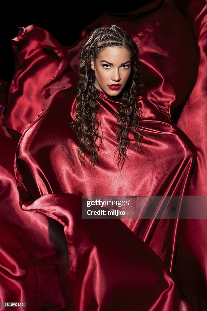 Erstaunliche Mode Models posieren auf rotem satin-Kleid