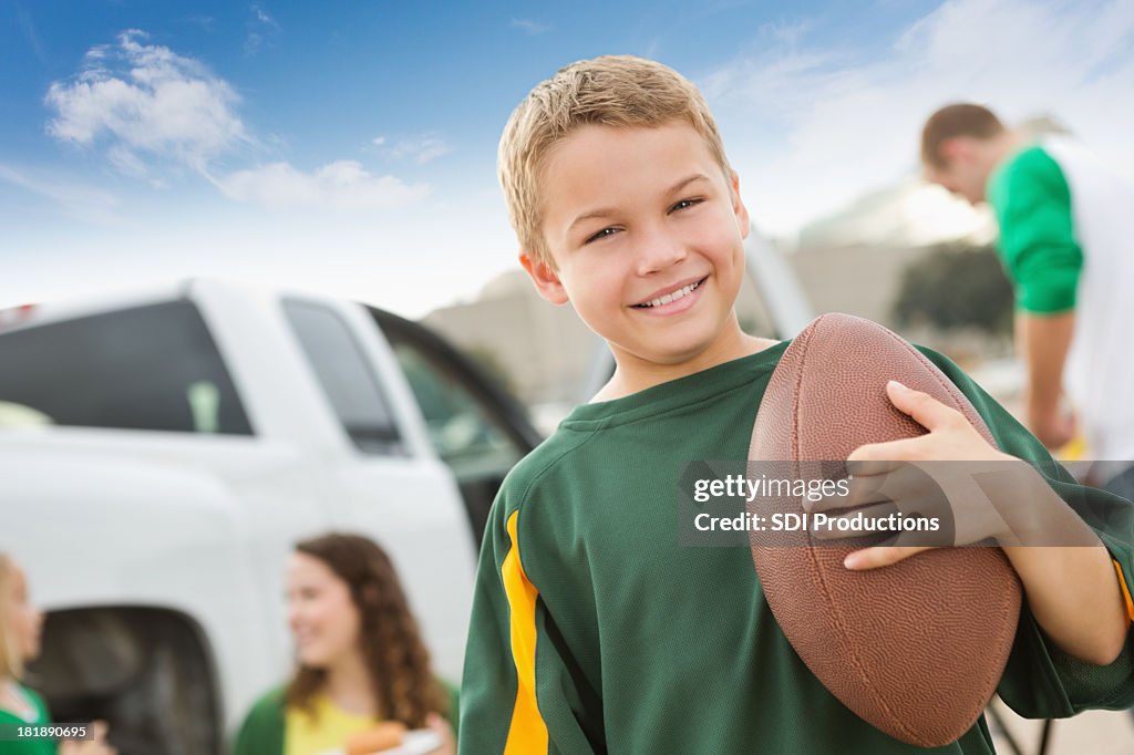 Young football fan at a tailgate party with his family