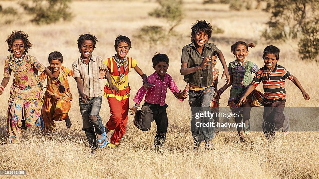 Group of running happy Indian children, desert village, India