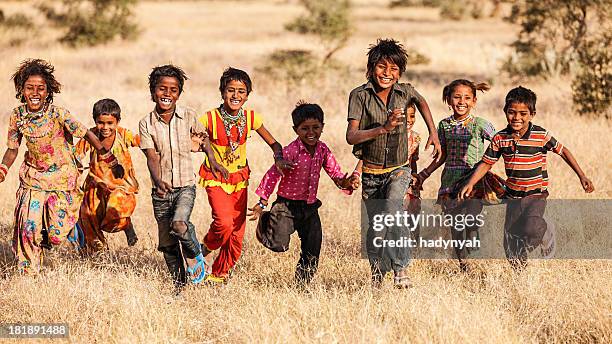 group of running happy indian children, desert village, india - childhood poverty stock pictures, royalty-free photos & images