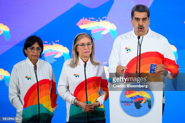 Nicolas Maduro, Venezuela's president, right, speaks to members of the media, next to First Lady Cilia Flores, center, and Delcy Rodriguez,...