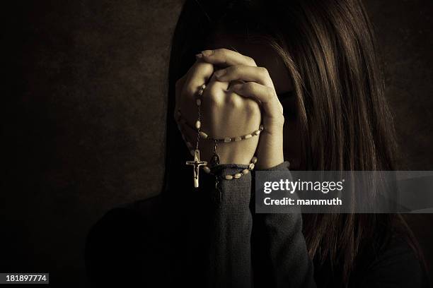 young catholic woman praying with rosary - rosary beads stock pictures, royalty-free photos & images