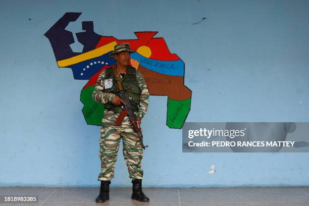 Member of the Bolivarian Militias stands guard at a polling station during a consultative referendum on Venezuelan sovereignty over the Essequibo...