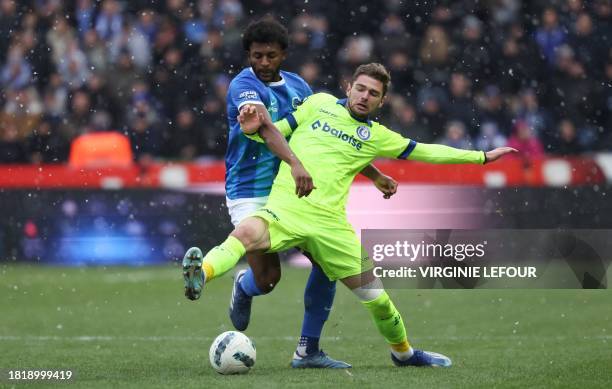 Genk's US defender Mark McKenzie and Gent's Belgian forward Hugo Cuypers fight for the ball during the Belgian Pro League football match between KRC...