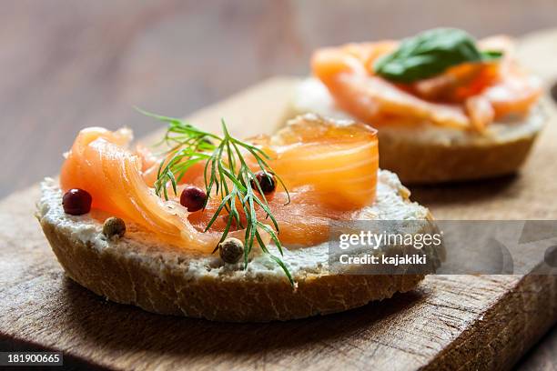 smoked salmon canapes on a brown wooden plate - tapas bildbanksfoton och bilder