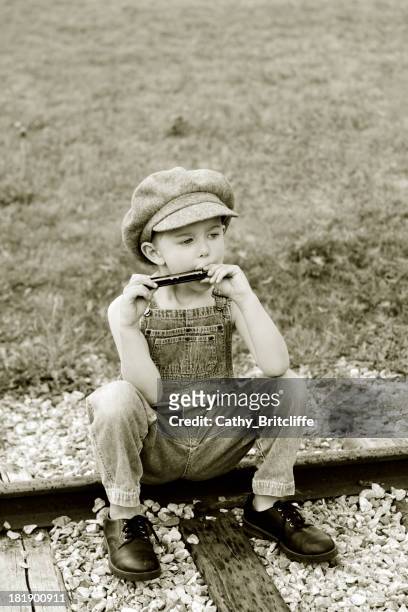 boy playing the harmonica - harmonica stock pictures, royalty-free photos & images
