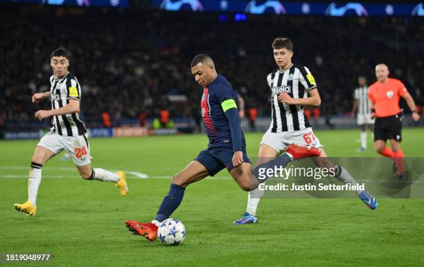 Kylian Mbappe of Paris Saint-Germain shoots whilst under pressure from Lewis Miley of Newcastle United during the UEFA Champions League match between...