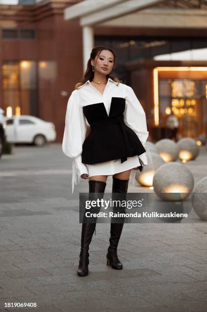 Guest wears long black boots, white long oversized shirt and black corset during the Tashkent Fashion Week 2023 on November 28, 2023 in Tashkent,...