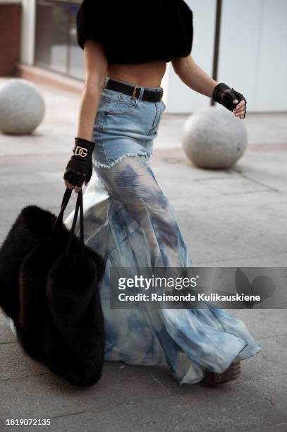 Guest wears long skirt part blue denim, part white and blue silk with a black belt, black leather gloves from Dolce and Gabbana, black big fur bag...