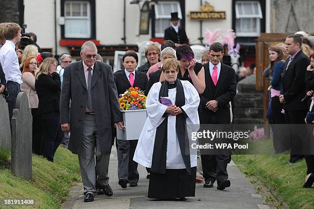 The Reverend Kathleen Rogers leads the cortege and family members carrying the coffin of murdered schoolgirl April Jones into St Peter's Church for...