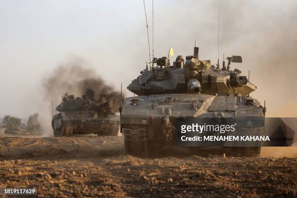 Israeli military tanks roll near the border with the Gaza Strip on December 3 amid continuing battles between Israel and the militant group Hamas....