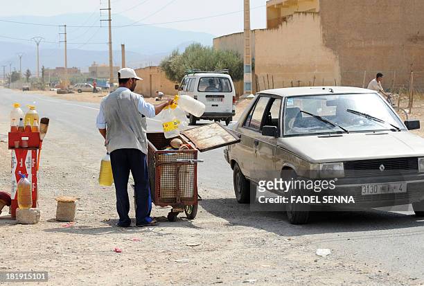 Smuggled oil vendor waits for customers on September 12, 2013 on the side of the road in Oujda, near Morocco's Mediterranean coast. Algerian...