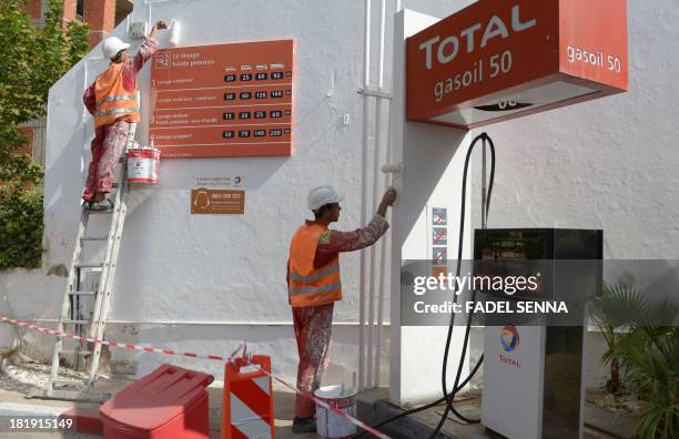 Workers paint walls of a new gas station on September 12, 2013 in Oujda, near the Moroccan-Algerian border. Algerian authorities launched an...