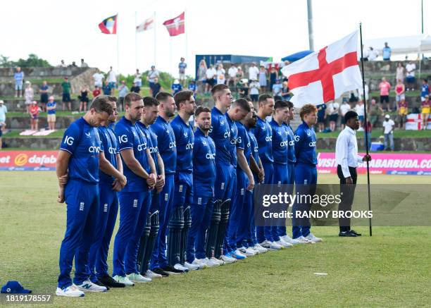 Members of the England team stand at attention for the national anthem during the first one day international cricket match between England and West...