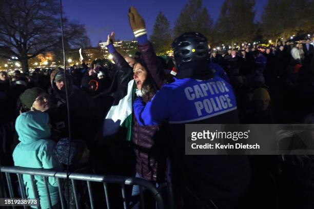 Pro-Palestine demonstrator is disrupted by U.S. Capitol Police as she protests during the U.S. Capitol Christmas Tree lighting ceremony on the West...