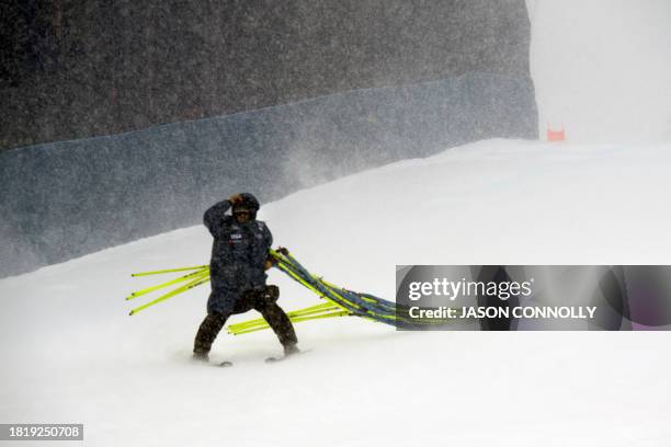 Race crew member carries equipment after the cancellation of the Men's Super-G events, during the FIS Ski World Cup Birds of Prey races at Red Tail...