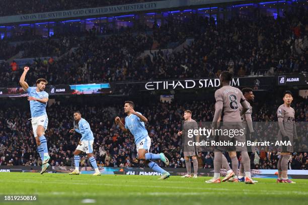 Ruben Dias of Manchester City celebrates the equaliser to masker it 1-1 as Son Heung-Min of Tottenham Hotspur reacts during the Premier League match...