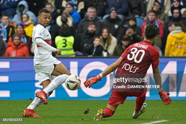 Paris Saint-Germain's French forward Kylian Mbappe challenges Le Havre's French goalkeeper Arthur Desmas during the French L1 football match between...