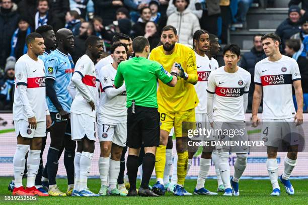 French referee Bastien Dechepy prepares to give a red card to Paris Saint-Germain's Italian goalkeeper Gianluigi Donnarumma during the French L1...