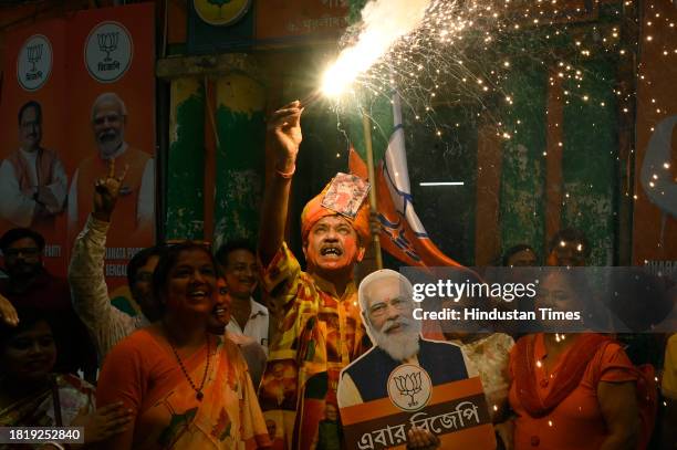 Bharatiya Janata Party supporters celebrate with poster of PM Narendra Modi after getting majority in Rajasthan, Madhya Pradesh and Chattisgarh...