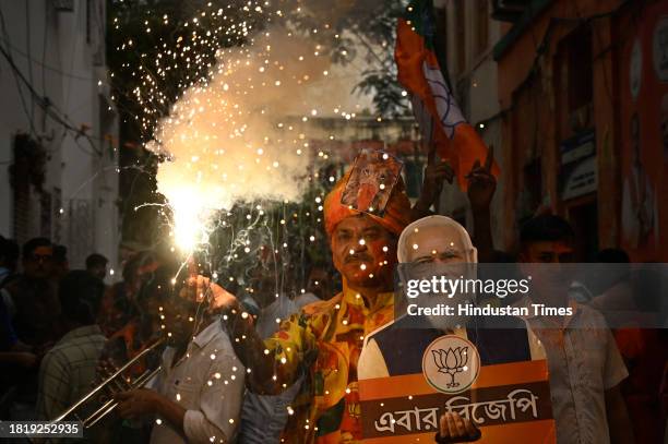 Bharatiya Janata Party supporters celebrate with poster of PM Narendra Modi after getting majority in Rajasthan, Madhya Pradesh and Chattisgarh...