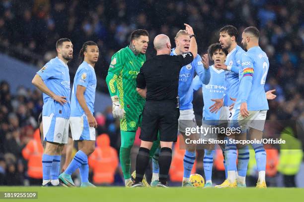 Manchester City players argue with referee Simon Hooper during the Premier League match between Manchester City and Tottenham Hotspur at Etihad...