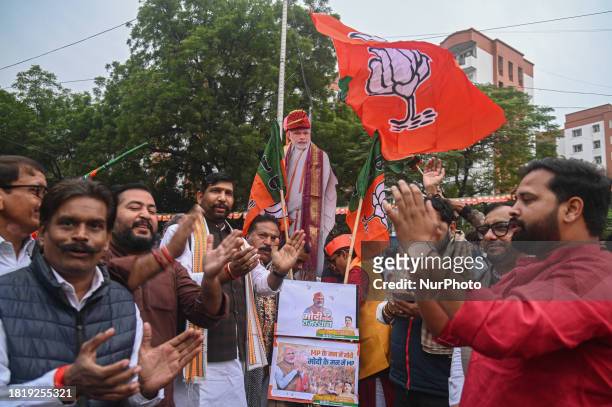 Bharatiya Janata Party supporters are celebrating outside the BJP headquarters during celebrations following the BJP's victory in three of the four...