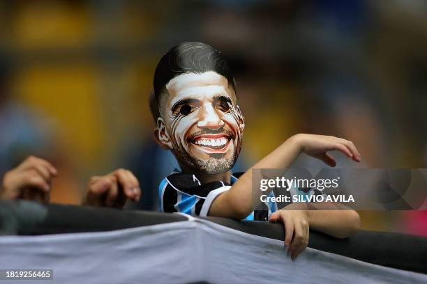 Fan of Gremio wears a mask of Uruguayan striker Luis Suarez before the start of the Brazilian Championship football match between Gremio and Vasco da...