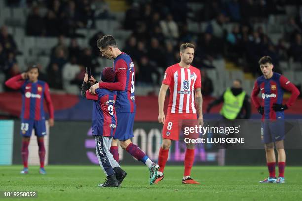 Young pitch invader interrupts the game to take a selfie photo with Barcelona's Polish forward Robert Lewandowski during the Spanish league football...