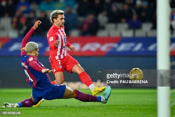 Atletico Madrid's French forward Antoine Griezmann is tackled by Barcelona's Uruguayan defender Ronald Araujo as he has an effort on goal during the...