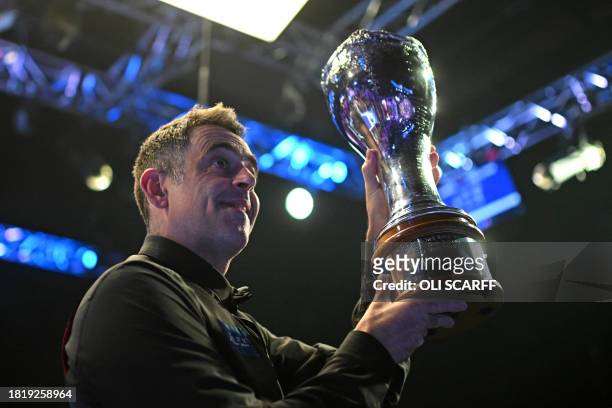 England's Ronnie O'Sullivan shows off the trophy after his victory over China's Ding Junhui in the final of the 2023 MrQ UK Championship at the York...
