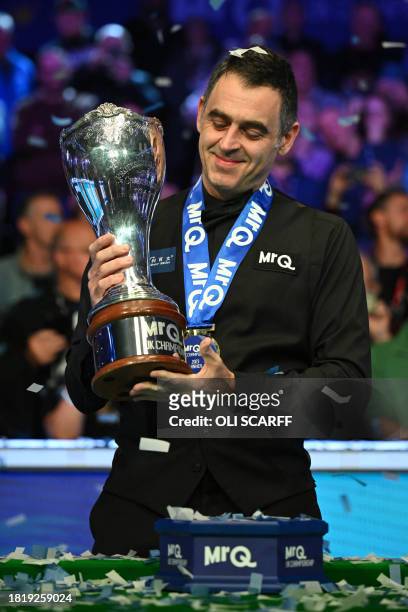 England's Ronnie O'Sullivan poses with the trophy after his victory over China's Ding Junhui in the final of the 2023 MrQ UK Championship at the York...