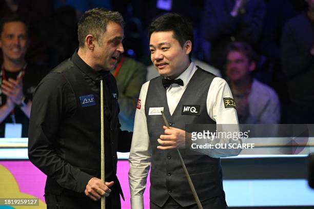 England's Ronnie O'Sullivan consoles China's Ding Junhui after beating him in the final of the 2023 MrQ UK Championship at the York Barbican in York...