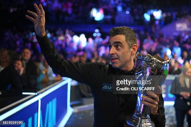 England's Ronnie O'Sullivan shows off the trophy after his victory over China's Ding Junhui in the final of the 2023 MrQ UK Championship at the York...