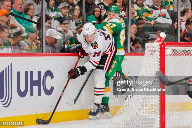 Kirill Kaprizov of the Minnesota Wild collides with Alex Vlasic of the Chicago Blackhawks during the game at the Xcel Energy Center on December 3,...