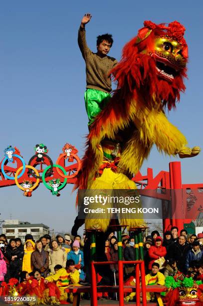 People watch lion dance performance at a historical street in Beijing on February 11, 2008. Millions of people braved China's overcrowded transport...