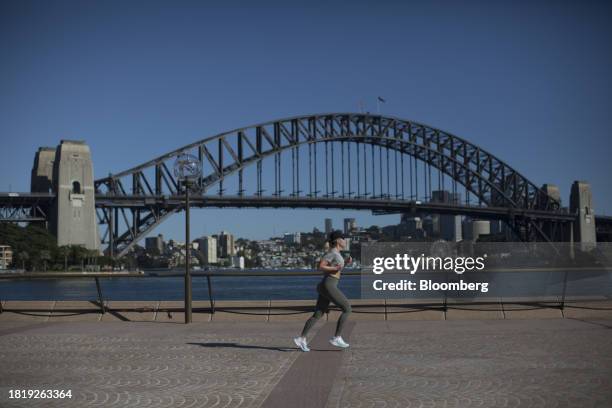 Woman runs past the Sydney Harbour Bridge in Sydney, Australia, on Sunday, Dec. 3, 2023. Australia will release its third-quarter gross domestic...