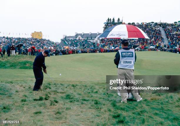 Justin Leonard of the United States pitches onto the green watched by his caddie during the British Open Golf Championship held at the Carnoustie...