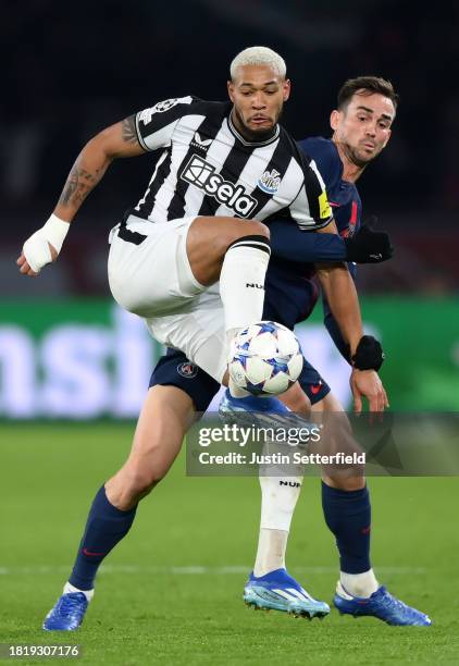 Joelinton of Newcastle United battles for possession with Fabian Ruiz of Paris Saint-Germain during the UEFA Champions League match between Paris...