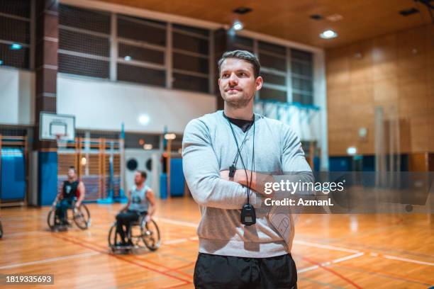 wheelchair basketball coach standing with his arms crossed - basketball coach stockfoto's en -beelden