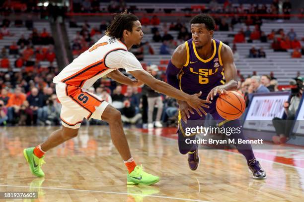 Chris Bell of the Syracuse Orange reaches in on Jordan Wright of the LSU Tigers during the first half at JMA Wireless Dome on November 28, 2023 in...