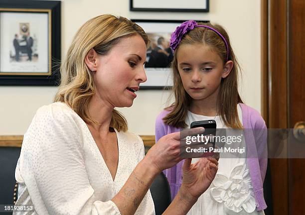 Super model Niki Taylor shows March of Dimes National Ambassador Nina Centofanti some photos while waiting for the arrival of Senator Lamar Alexander...