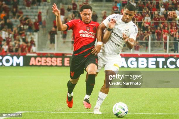 Vitor Roque of Athletico PR is contesting the ball with Joaquim of Santos during the Brazilian League Serie A 2023 Round 37 match at Arena da Baixada...