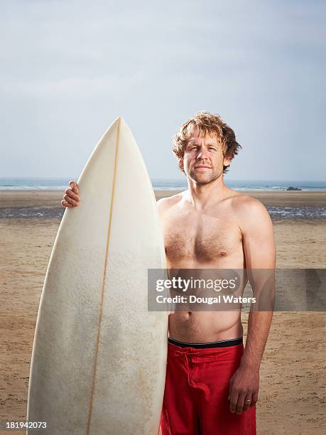 portrait of man at beach with surfboard. - human age stock pictures, royalty-free photos & images