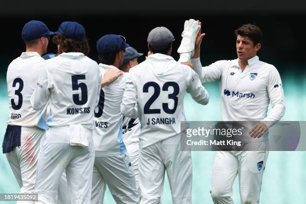 Moises Henriques of New South Wales celebrates with team mates after taking the wicket of Jordan Silk of the Tigers during the Sheffield Shield match...
