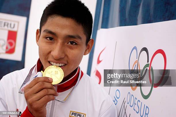 Michael Patiño of Peru bites the golden medal after the Men's 55kg Final as part of the I ODESUR South American Youth Games at Gimnasio Villa...