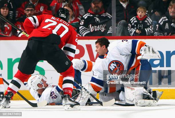 Brock Nelson falls over Ilya Sorokin of the New York Islanders knocking his mask off during the third period against the New Jersey Devils at...