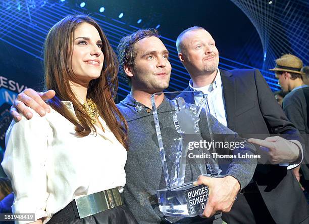 Bosse of Niedersachsen stands with entertainer Stefan Raab and moderator Sandra Riss after winning the Bundesvision Song Contest 2013 at SAP Arena on...