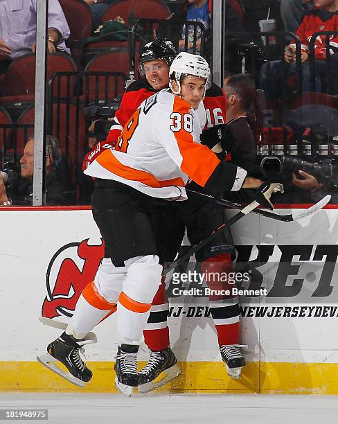 Oliver Lauridsen of the Philadelphia Flyers hits Jacob Josefson of the New Jersey Devils into the boards during the first period at the Prudential...